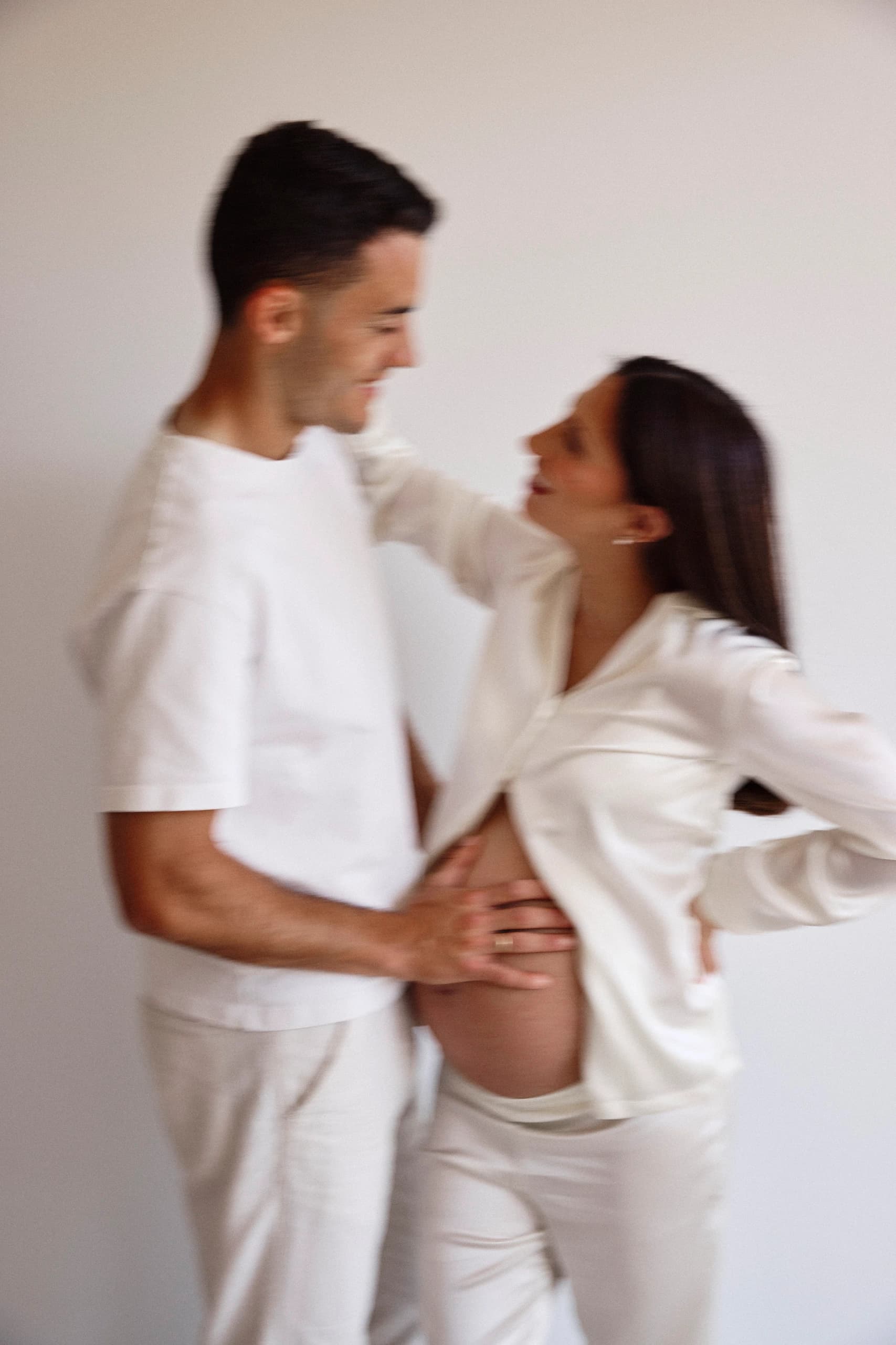 Pareja abrazada con la mano sobre el embarazo
