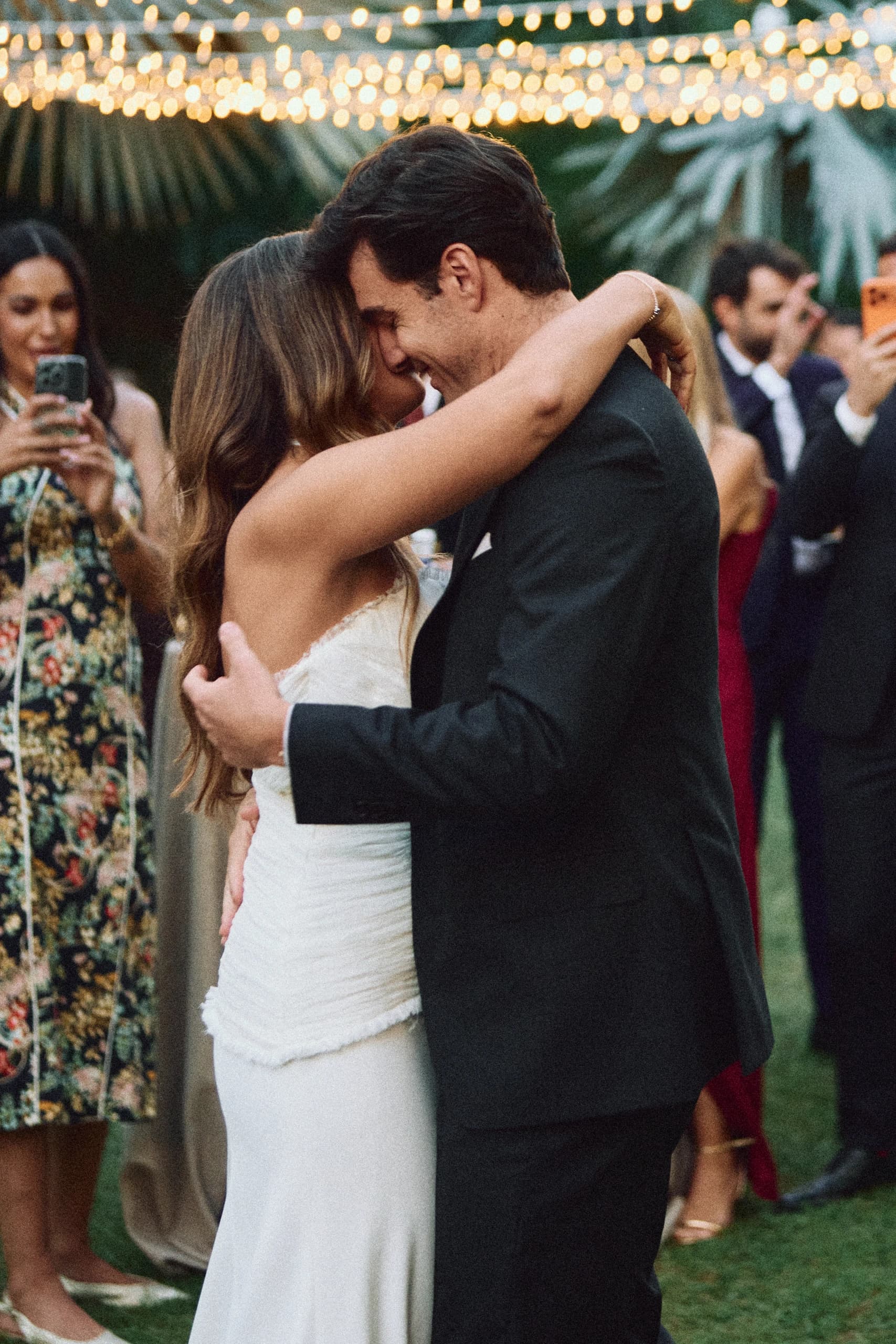 Novios abrazándose entre los invitados