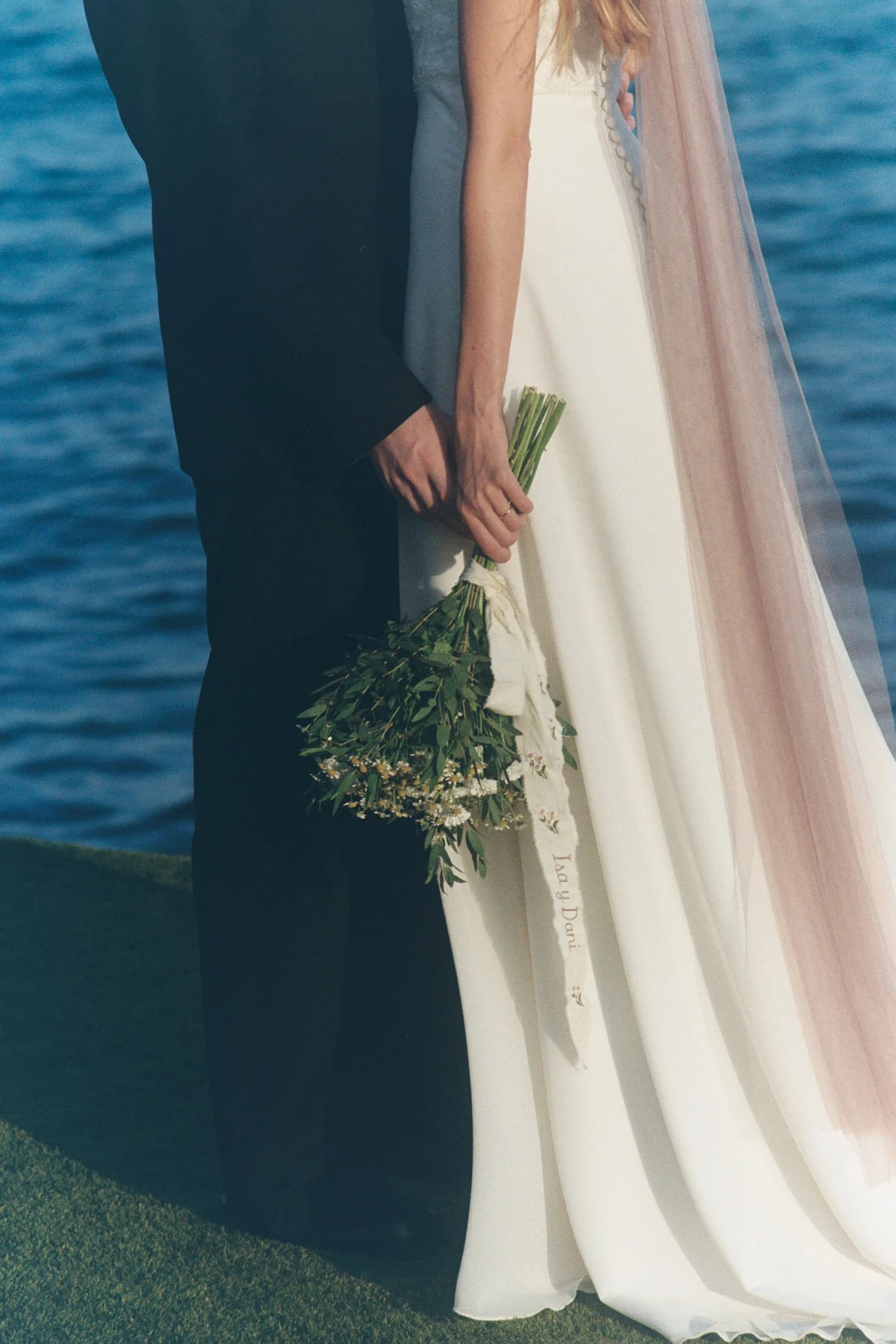 Detalle del vestido de la novia junto al traje del novio