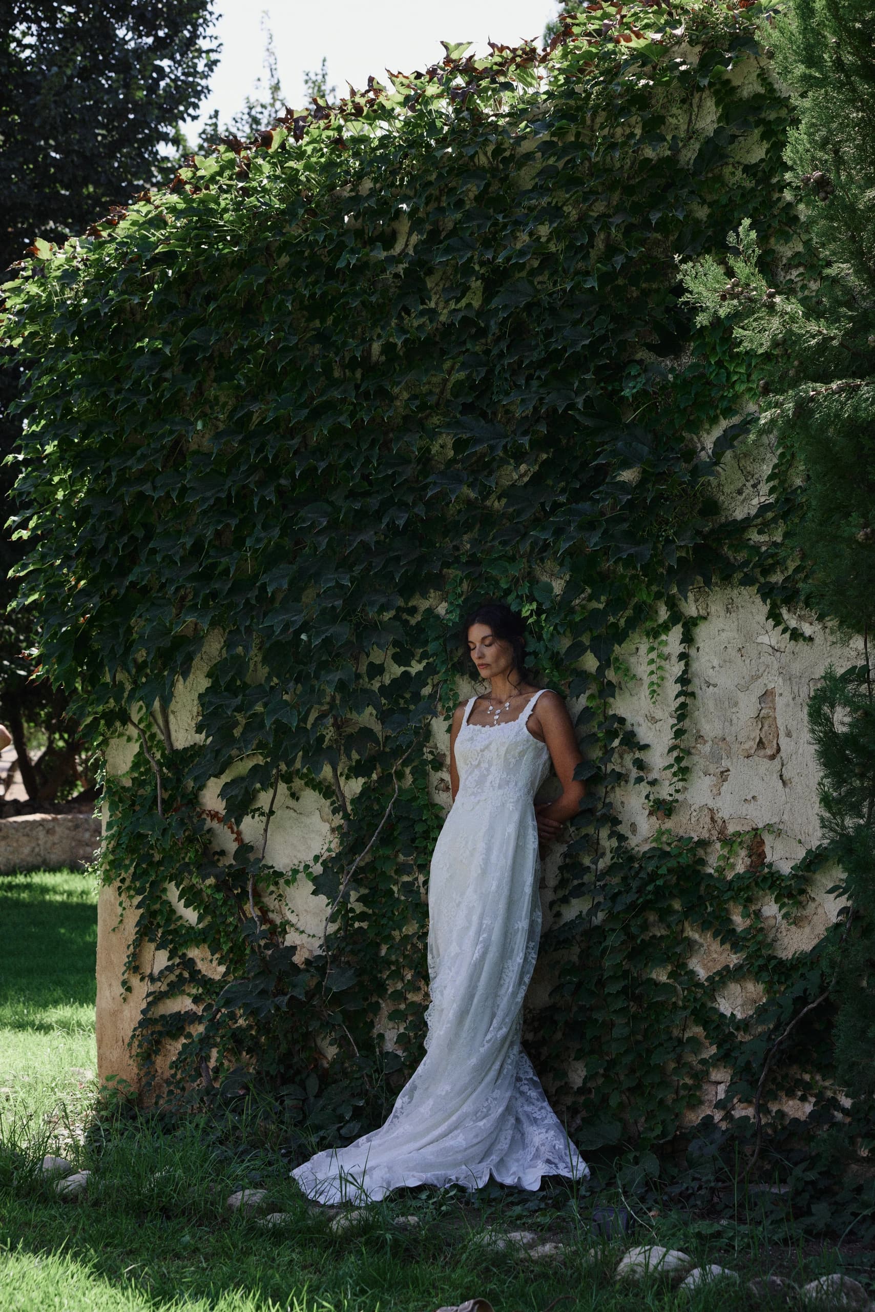 Novia de pie entre la vegetación del jardín