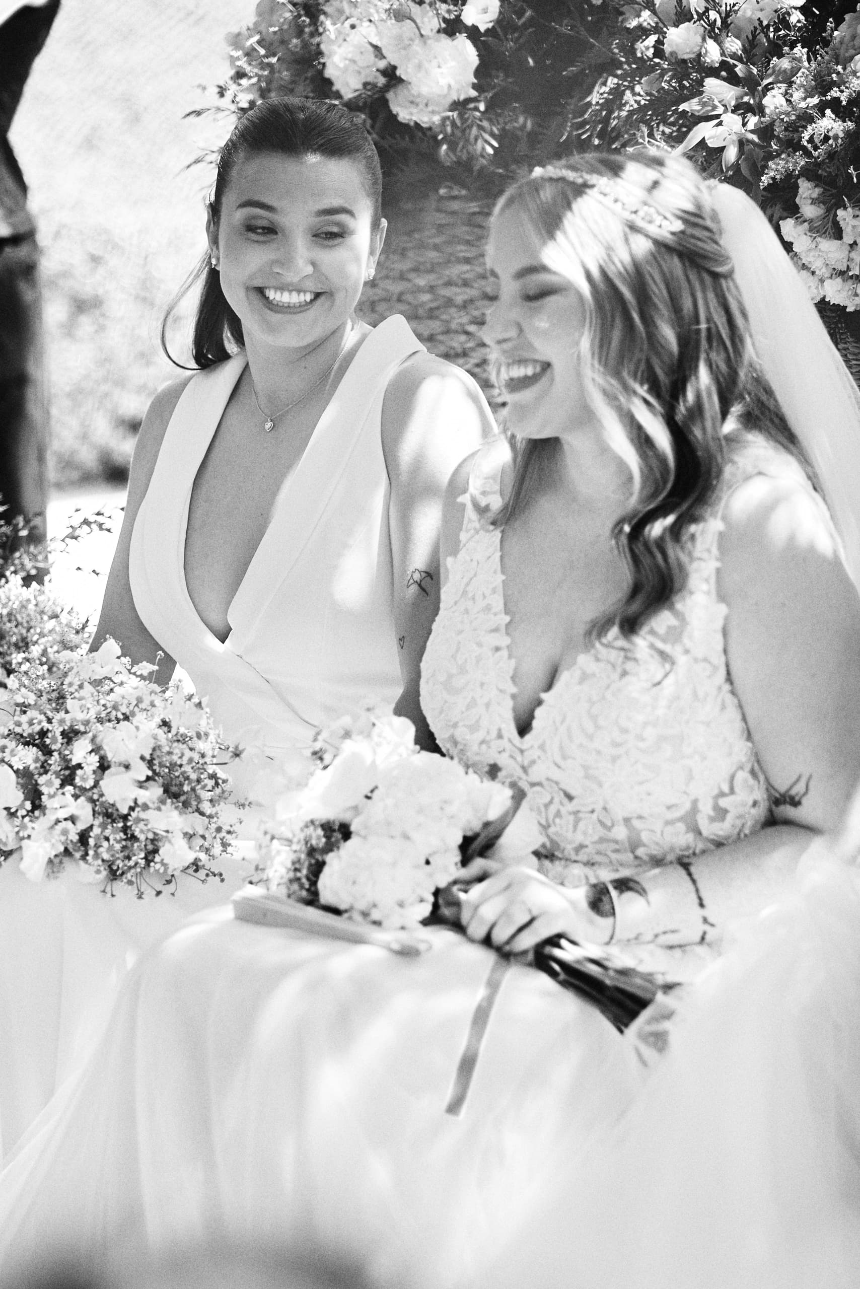 Dos novias sonriendo en un retrato en blanco y negro